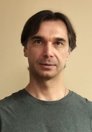 Portrait of a man with neutral expression against a plain background.